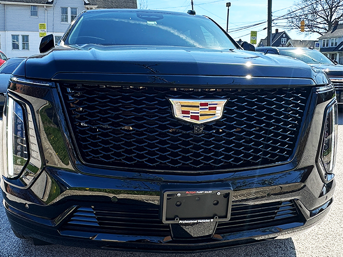 Front view of a black Cadillac SUV showing the prominent mesh grille and Cadillac emblem centered on the grille